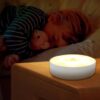 Baby beside a mootion sensor light